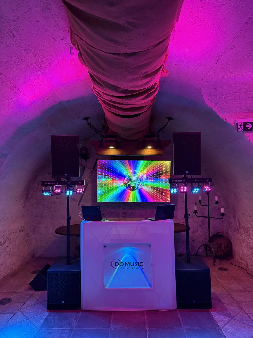 DO MUSIC DJ-Pult mit K.M.E.-Boxen und buntem Licht in einem Gewölbekeller
