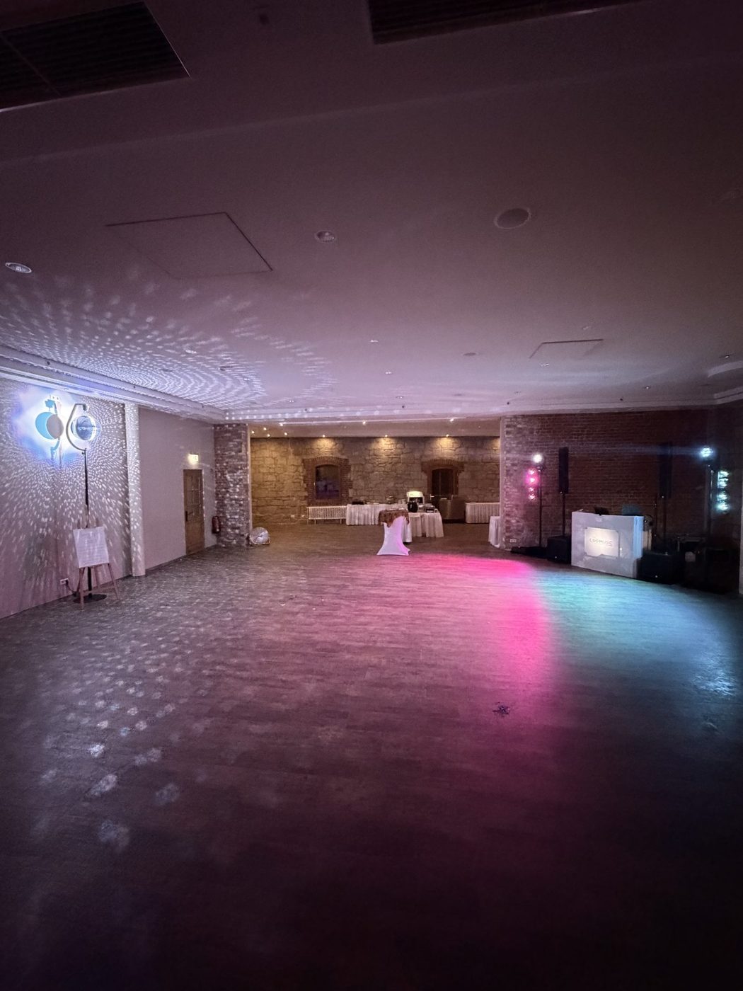 Saal mit pink-violettem Licht und DO MUSIC Pult
