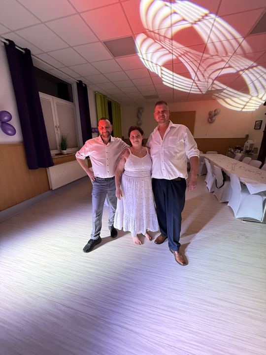 Tanzfläche in violettem Licht: DJ Marco Hilse mit Brautpaar bei der Hochzeitsfeier